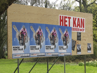 905258 Afbeelding van affiches voor de Ronde van Italië, die op 9 mei de stad aandoet, geplakt op een verkiezingsbord ...